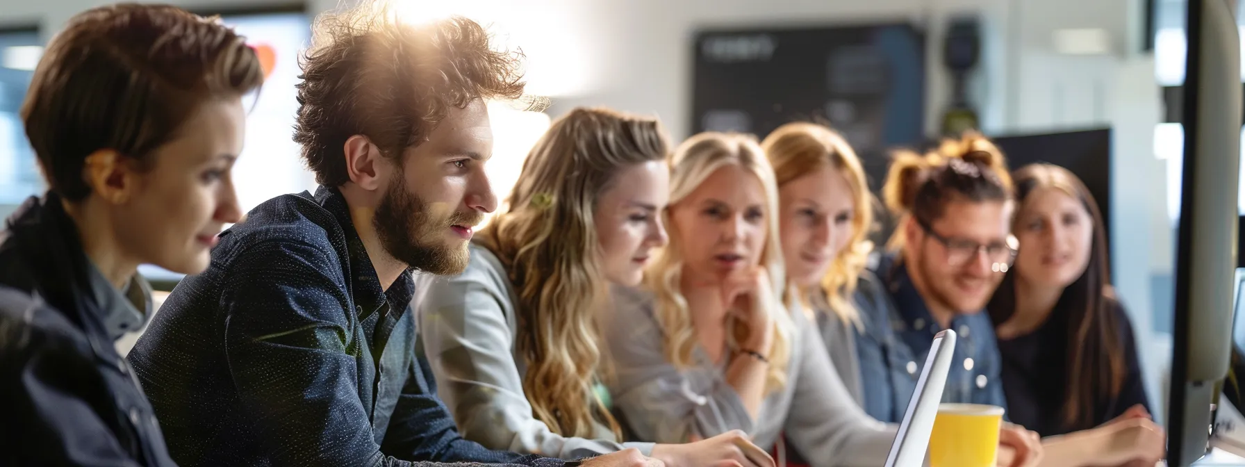 Seven employees learn how to use Altify TeamView at a desktop computer